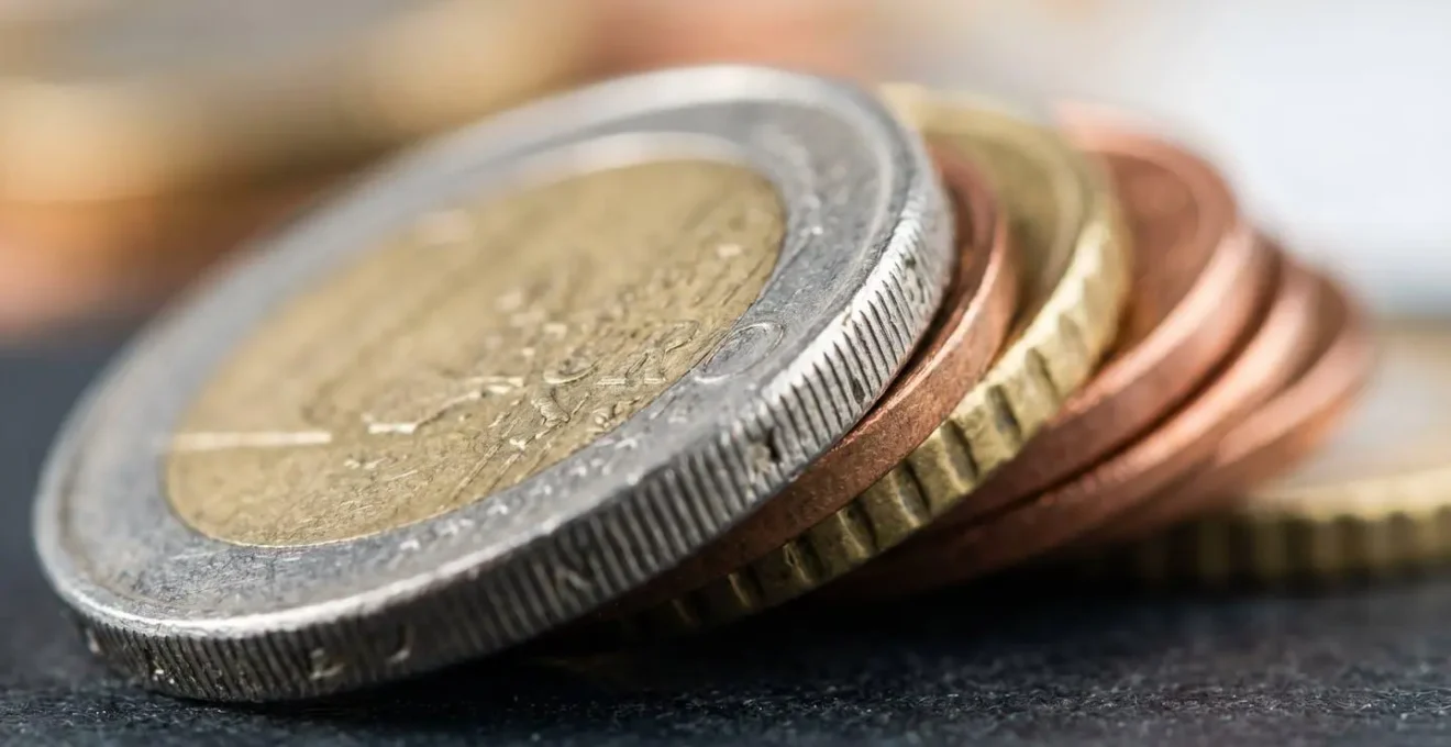 Macro détail de pièces de monnaie empilées avec une texture métallique visible sous un éclairage doux